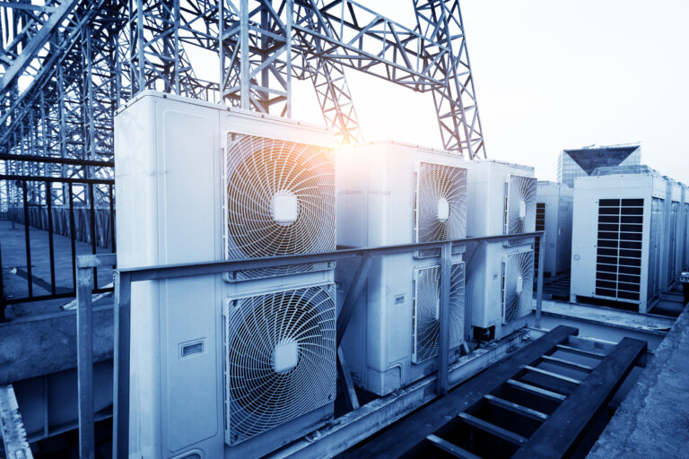 Industrial HVAC units on rooftop at sunrise