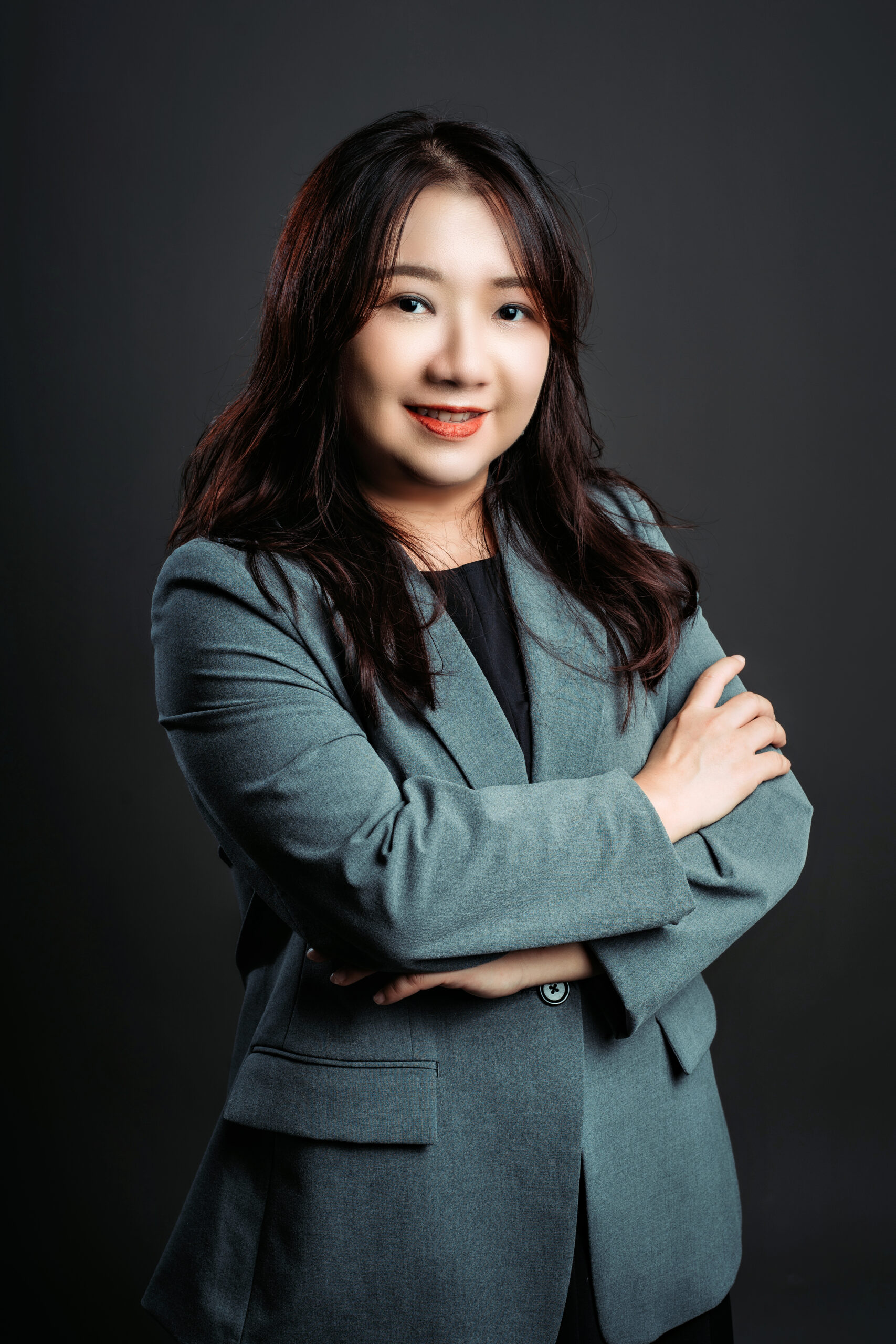 Woman in grey blazer with arms crossed