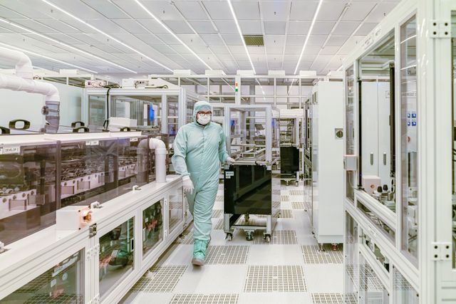 Man in cleanroom suit walks through lab