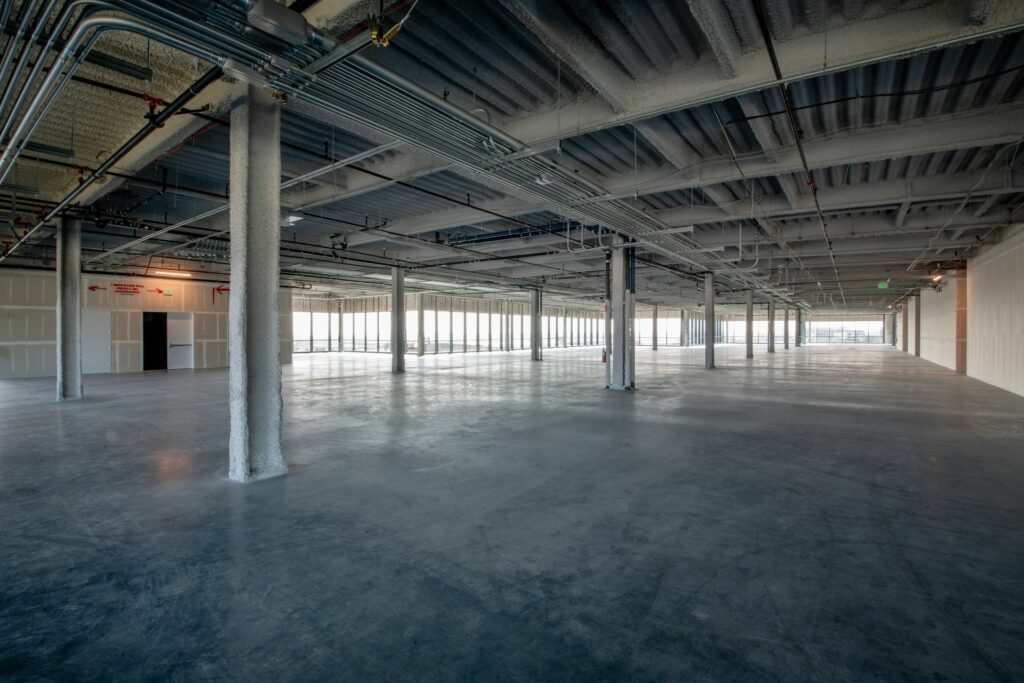 Large, empty industrial space with exposed pipes